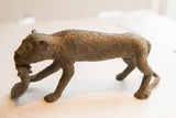 Side profile of the textured vintage African cheetah sculpture carrying prey.