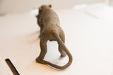 Rear view of the vintage cheetah sculpture showing the textured pattern on its hindquarters and curled tail.