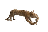 Vintage African cheetah sculpture holding prey, with a textured surface and raised spiral motifs.