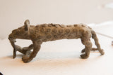 Vintage African cheetah sculpture in profile, showing its elongated form and rustic, spiral-patterned texture.