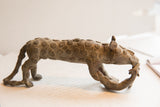 Side profile of a vintage African cheetah sculpture showing its textured spiral patterns.