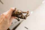 A hand holding the vintage cheetah sculpture, showing its scale and textured surface.