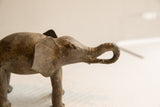 Close-up of the elephant sculpture's head, highlighting its handmade texture and curled trunk.
