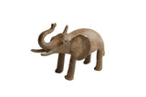 Vintage handmade African elephant sculpture with a weathered, dark brown body and raised trunk.