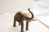 Textured details on the head of a vintage elephant sculpture with its trunk raised.