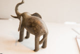 Rear view of the vintage elephant sculpture showing its textured, aged surface.