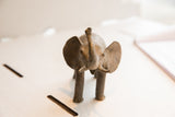 Frontal view of a vintage African elephant sculpture showing its expressive face and raised trunk.