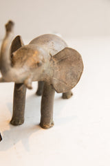 Angled view of a vintage elephant sculpture highlighting its textured body and large ear.