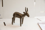 Handmade African antelope sculpture with a braided spine detail and aged patina.
