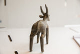 The back of a vintage antelope sculpture showing the ridged spine and aged, earthy texture.