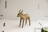 Side profile of the vintage antelope sculpture showing its textured spine and aged patina.