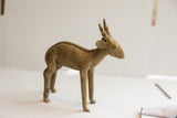 Profile of a vintage antelope sculpture showing its rustic texture and braided spine.