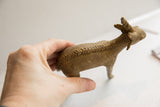 The rustic, carved spine detail of the vintage African antelope sculpture held in hand.