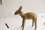 Vintage African antelope sculpture showing its textured spine and aged patina.
