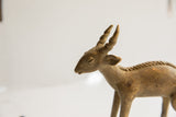 Close profile of the vintage antelope sculpture's head, showing its textured finish.
