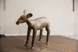 Side view of a vintage African ewe sculpture showing its weathered, earthy patina and form.