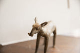 Close detail of the stylized head and snout on the vintage African ewe sculpture.