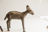 Side profile of a vintage African ewe sculpture highlighting its rustic, handmade texture.