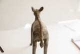 Back view of a vintage ewe sculpture showing the detailed texture of its spine and tail.