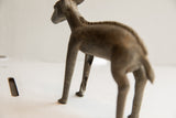 Detail of a handmade African ewe sculpture's leg showing rustic texture and vintage patina.
