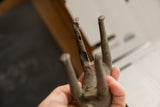 Detail of the vintage African sculpture showing the weathered texture and aged patina on its legs.