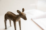 The rustic, handmade surface and expressive ears of the vintage African ewe sculpture.