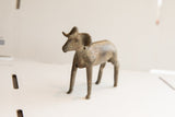 Vintage African ram sculpture seen from the side, showing its aged patina and form.