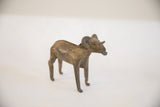 Angled profile of the vintage African ram sculpture showing its rustic, handmade texture.
