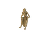 Vintage handmade African sculpture of a sitting monkey eating a banana with aged patina.