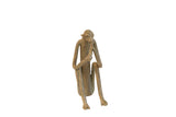 Vintage African handmade sculpture of a sitting monkey eating, with a weathered metallic patina.