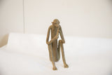 Front view of a vintage African monkey sculpture in a seated eating pose.
