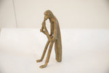 Side view of the sitting monkey sculpture highlighting its slender form and weathered patina.