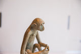 Profile view of the vintage monkey sculpture's head showing its textural patina.