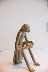 Side view of the vintage African monkey sculpture highlighting its slender profile.