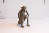 Three-quarter view of a vintage handmade African monkey sculpture.