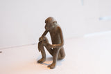 Profile view of a handmade African monkey sculpture with a rustic, aged finish.