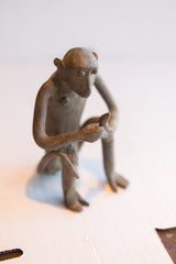 Angled overhead view of the seated African monkey sculpture holding a banana.