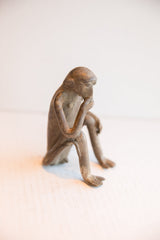Side view of the pensive African monkey figurine showing its weathered patina.
