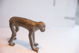 Side profile of a vintage African monkey figurine highlighting its textured, aged patina.