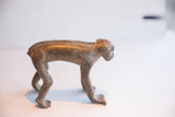 Side profile of the handmade African monkey figurine showing its textured spine and form.
