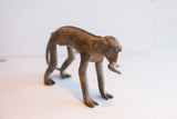 Side profile of the vintage African monkey figurine with a banana, showing its aged finish.
