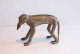 Side profile view of the handmade African monkey figurine showing its textured back.