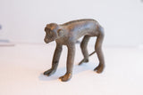 Vintage African monkey figurine in profile, highlighting its textured spine and aged patina.