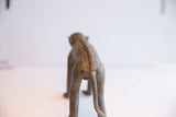 Rear view of the vintage handmade monkey figurine showing its textured spine and tail.
