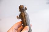 The textured back and detailed stitched spine of a vintage African monkey figurine.