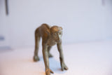 Detailed front view of a vintage African monkey figurine with a rustic, handmade texture.