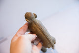 Carved details along the spine and aged patina of a vintage African monkey figure.