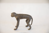 Profile of the vintage African monkey figurine, showing its handmade texture and form.