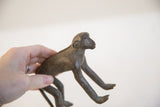 Vintage African monkey figurine held in hand to demonstrate its scale.