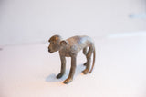 Vintage African monkey sculpture in profile, highlighting its slender form and textured patina.